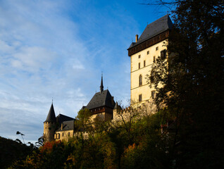 Fototapeta na wymiar View of large Gothic Karlstejn Castle on top of hill on sunny autumn day, Czech Republic..