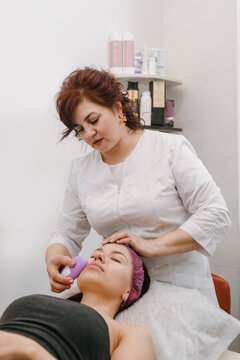 Young woman having ultrasound facial massage in beauty salon