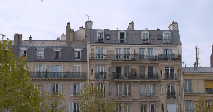 View of an Haussmannian building. Typical parisian facade. Balconies and roof in Paris.