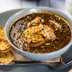 A bowl of French Onion Soup, served with toasted bread