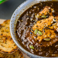 A bowl of French Onion Soup, served with toasted bread