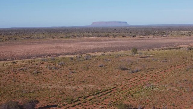 an aerial ascending shot of mt conner as viewed  from the lookout on a winter morning in the northern territory of australia