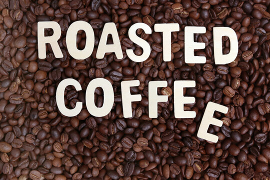 Roasted coffee word on roasted coffee beans background. Concept for cafe ,coffee shop and drinking coffee beverage.