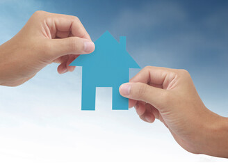 Hands holding paper house, family home  protecting insurance concept