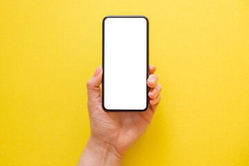 Mobile phone with empty screen in hand on yellow background