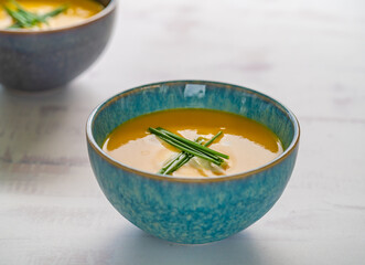 carrot soup or pumpkin soup with garnish in turquoise bowl