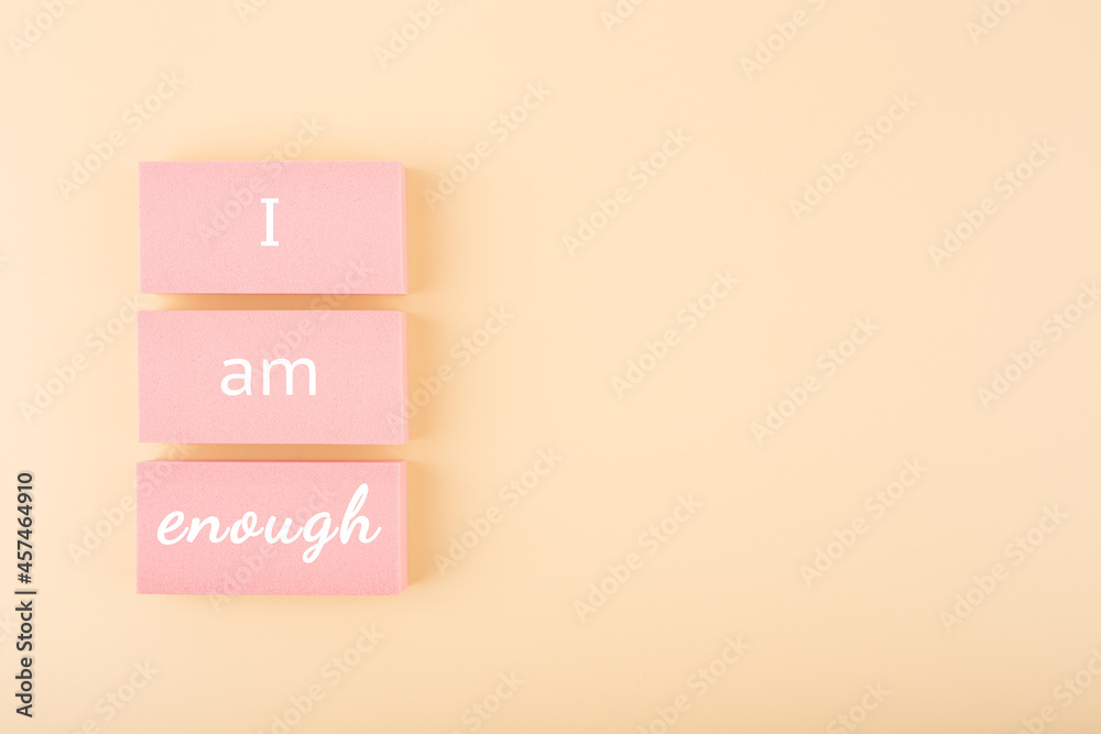 Wall mural i am enough minimal concept on bright pastel beige background with copy space. mental health and sel