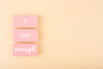 I am enough minimal concept on bright pastel beige background with copy space. Mental health and...