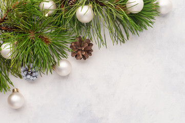 Pine branches, Christmas balls and pine cones on a white background. Stylish frame for your inscription. Christmas, New Year, congratulation, postcard, banner, poster.