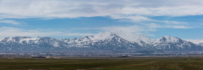Fototapeta na wymiar トルコ　エルズルムの郊外から見える街並みと雪の積もったパランドケン山