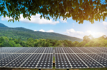 Green leaves frame with photovoltaic solar power panel at landscape lake views nature forest Mountain and view spring blue sky background, green clean Alternative power Eco energy concept.