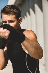 Man exercising and fighting in outside, boxer in gloves. male boxer portrait