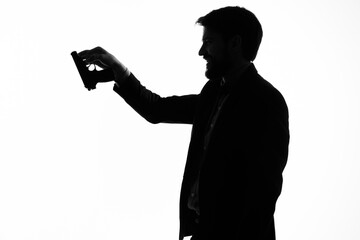 The man in a suit with a pistol in hand crime hand gesture light background