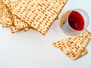 A stack of Jewish traditional matzah bread and a glass of red wine. High angle view. Concept - Jewish Easter, traditions, religion, Judaism, synagogue, rituals.