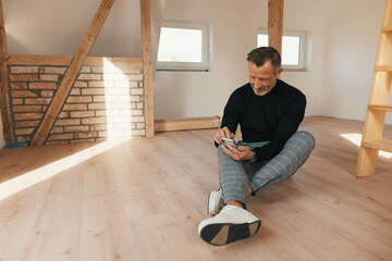 Homeowner sitting on the floor in a newly renovated house