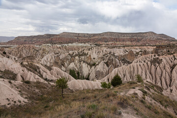 トルコ　カッパドキアのギョレメ国立公園のレッドバレーの奇岩群と洞窟住居と後ろに広がるローズバレー