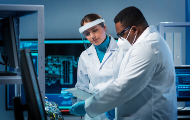 Group of microelectronic engineers discussing in a modern microprocessor manufacture lab. Workplace...