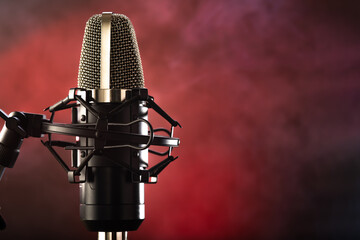 Professional studio microphone on a blue-red background. Nice lighting. Minimalism. Recording studio, professional equipment, vocals, instruments, music.