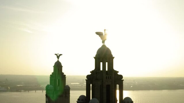 Liverpool Icons the liverbirds that sit on top of the famous Liverbuilding on Liverpools waterfront. Cinematic sun flare and drone rotation.