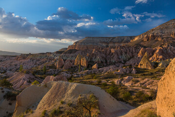 トルコ　カッパドキアのギョレメ国立公園のローズバレーの夕陽に当たってピンク色に染まった奇岩群と洞窟住居