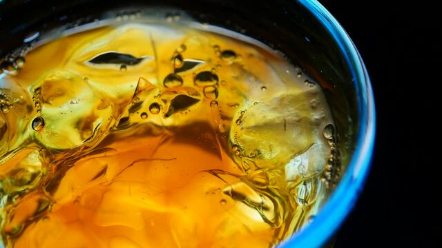 氷と飲み物がくるくる回るクローズアップ動画。コーヒーやウィスキーなど。