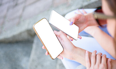 Unrecognizable two persons holding mobile smart phone next to each other sharing mockup white...