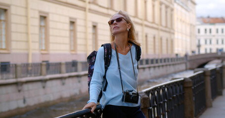 Portrait of middle aged woman tourist visiting town