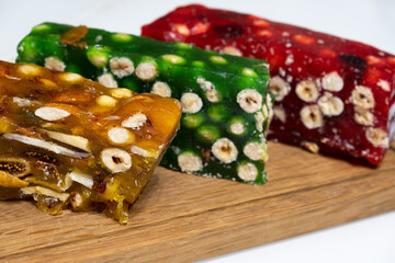 Turkish delight. Oriental orange, green and red candy marmalade. Eastern sweets with sugar and nuts. Lukum is on white background. Delicious food. Dessert for dreams. Lukum on wooden board. Isolated