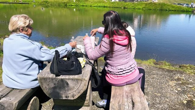 Happy family having a picknic at wonderful alpin lake.