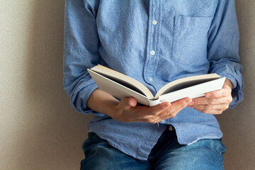 室内で座って読書する青いシャツを着た女性