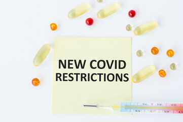 text new covid restrictions on paper background, medical concept.