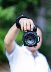 Asian man holds the Medium Format Camera in his hand and focus to shoot in front of him.