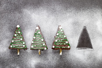 Drei von vier weihnachtlich dekorierte Kuchenstücke als Christbäume mit Zuckerguss, Sternen und...