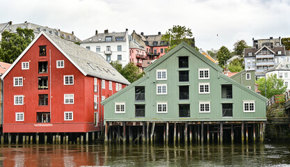 Typical colorful scandinavian buildings on a river in Trondheim in a cloudy rainy day