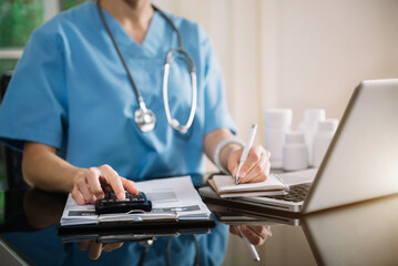 Doctor or accounting department writes a note and uses a calculator to calculate expenses - income....