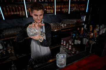Professional male bartender makes an alcoholic cocktail