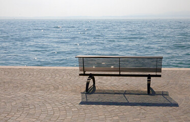 Fototapeta na wymiar bench on the shore with the water symbol of tranquility and experience