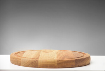 
Wooden round kitchen board on white table