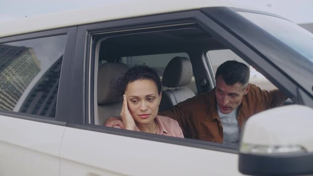 Husband apologizing to sad wife, hugging in the car, family love, forgiveness