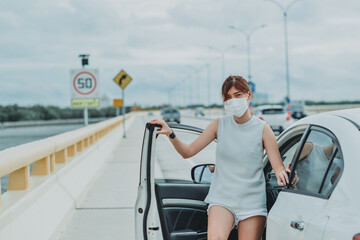 Asian woman   wearing protective face mask protection safety before getting out of the car during coronavirus covid-19 outdoor curfew pandemic