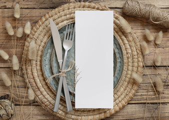 Blank paper card on plates with dried plants