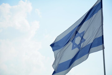 Israeli flag weaving in the wind against bright skies