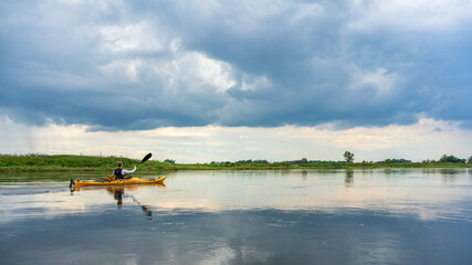 Obraz na płótnie Canvas Kayaking on the Elbe river under a dramatic sky