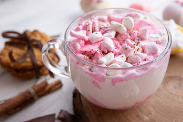 Hot drink with marshmallows on a wooden table.