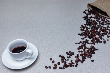 Сup of coffee with coffee beans on the table. Sack of coffee beans.