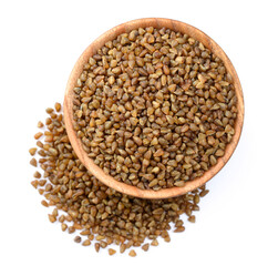 uncooked bitter buckwheat in the wooden bowl, isolated on the white background, top view