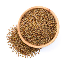 uncooked buckwheat in the wooden plate, isolated on the white background, top view