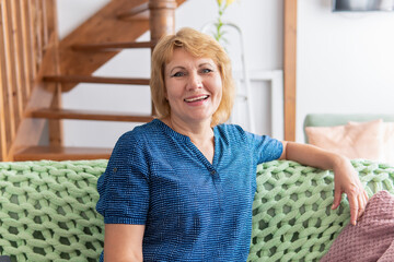 A woman is sitting on a sofa in a room in the house.