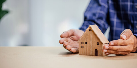 Insurance agent complete wooden model of the house with last piece with text insurance.Property...