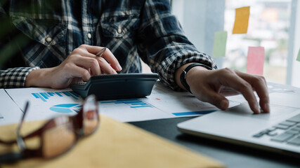 Business woman using calculator for do math finance on wooden desk in office and business working background, tax, accounting, statistics and analytic research concept.